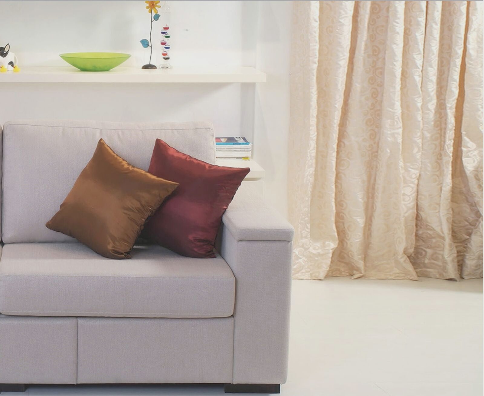 A custom-made Gorgeous sofa with silk cushions beside a full-length drape
